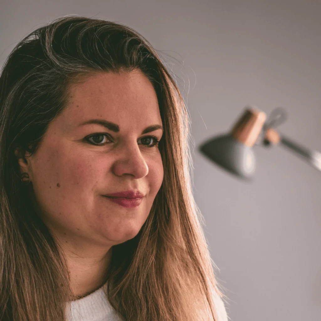 Portrait d'Anne Rouyer souriante aux cheveux lâchés, ambiance douce et naturelle.